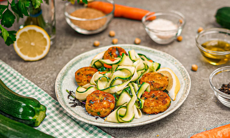 Un plato con ensalada de calabacín y bolas de falafel.