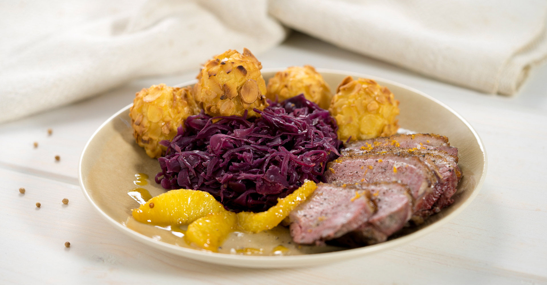 Pechuga de pato frita con salsa de naranja, bolitas de almendras y col lombarda